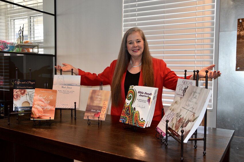 Andrea Lende with several of her published books that she has written through the years.